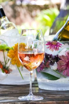 a glass of wine sitting on top of a wooden table