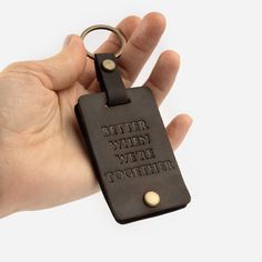 a hand holding a leather keychain that says, better when we're together