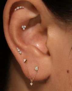 a close up of a person's ear with three different types of piercings