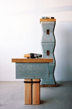 a pair of shoes sitting on top of a wooden bench in front of a white wall