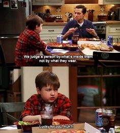 two boys sitting at a table eating pizza