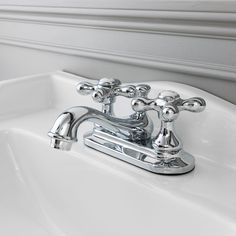 a white sink with chrome faucet and soap dispenser on it