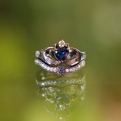 a ring with a heart shaped blue stone in it