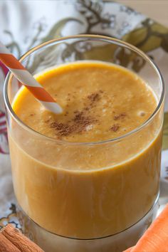 a glass filled with carrot juice and topped with an orange slice