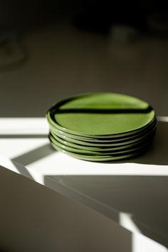 a stack of green plates sitting on top of a table