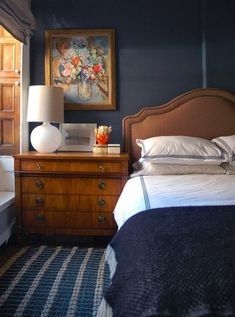 a bed room with two beds and a painting on the wall