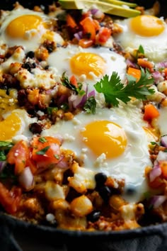 two eggs are on top of some vegetables in a skillet with other food items