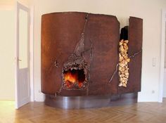 a fire place in the middle of a room with wood stacked on top of it