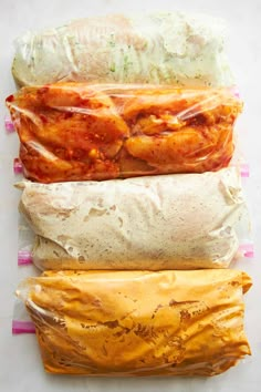 three burritos wrapped in plastic wrap sitting on top of each other next to one another