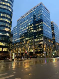 two tall buildings sitting next to each other in front of a traffic light at night