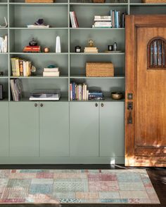 a bookshelf filled with lots of books next to a wooden door