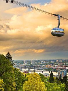 a gondola with the city in the background on a cloudy day at dusk