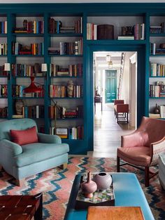 a living room filled with lots of furniture and bookshelves