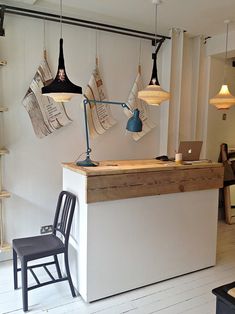 an empty room with chairs and lights hanging from the ceiling, in front of a counter