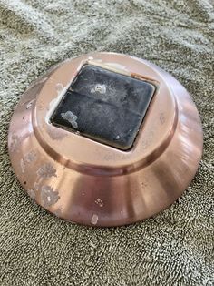 an electronic device that is sitting on the ground with dirt all over it's surface