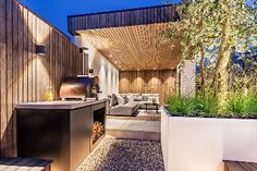 an outdoor kitchen and living room are lit up at night