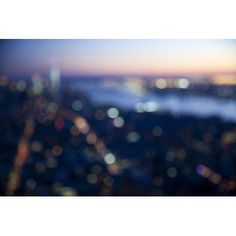 blurry image of city lights in the distance from an airplane window at night time