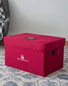 a red storage box sitting on top of a rug