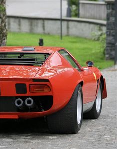 a red sports car is parked on the street