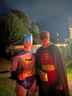 two men dressed as batman and robin wayne standing next to each other in front of a house