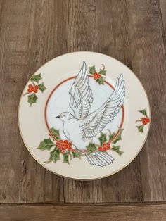 a white plate with holly and a bird on it