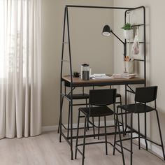 a table with four chairs and a mirror in the corner, next to a window