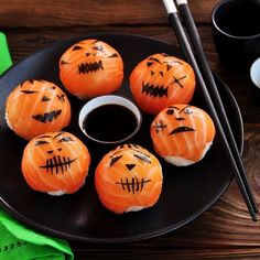 pumpkins with faces painted on them and chopsticks in front of the plate