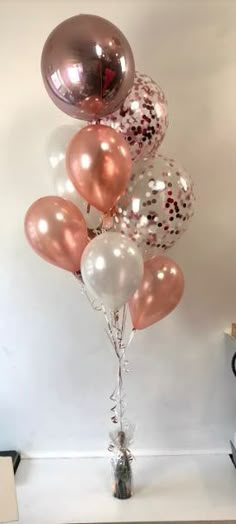 a bunch of balloons that are in the shape of a heart on a table with a vase