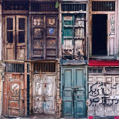 an old building with multiple doors and windows in different colors, including blue, green, brown, and white