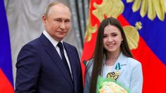 two people standing next to each other in front of flags