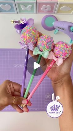 a person is holding three candy lollipops in their hands and they are decorated with colorful sprinkles