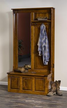 a wooden coat rack sitting next to a pair of cowboy boots