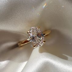 a diamond ring sitting on top of a white cloth