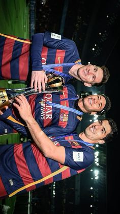 three men are holding trophies and posing for the camera in front of an audience at a sporting event