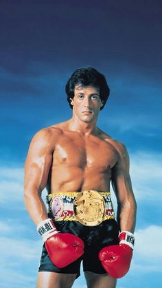 a man with boxing gloves on posing for a photo in front of a blue sky