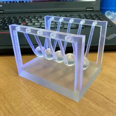 four plastic balls are placed in front of a laptop computer on a wooden table with a keyboard behind it