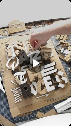 a person is making letters out of cardboard