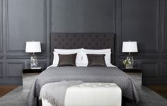 a bedroom with black walls and white bedding