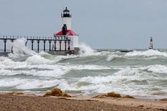 a lighthouse in the ocean with waves crashing around it