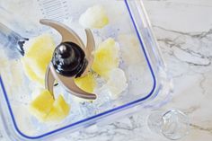 a blender filled with food on top of a marble countertop next to a measuring cup