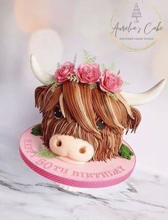 a cake shaped like a cow with flowers on its head