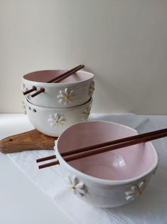 two bowls with chopsticks are sitting on a table