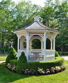 a white gazebo surrounded by lush green grass