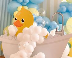 a bathtub filled with balloons and a rubber ducky