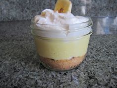 a dessert in a glass jar with whipped cream and a banana peel on the top