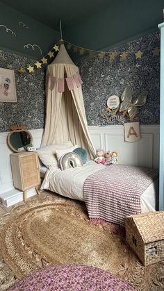 a child's bedroom with a canopy bed and rug