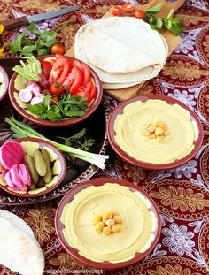 a table topped with bowls filled with different types of food next to tortillas