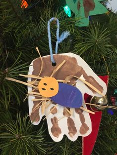 an ornament hanging from a christmas tree with scissors in it's hand