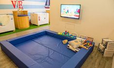 an inflatable play area with toys on the floor and a flat screen tv