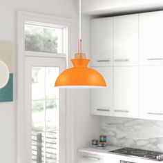 an orange light hanging over a kitchen counter